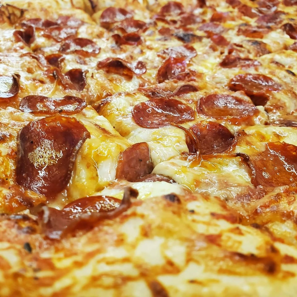Close-up of a freshly baked pepperoni pizza with melted cheese and crispy edges.