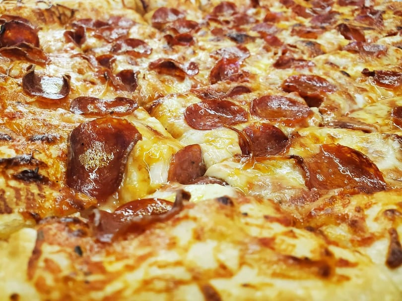Close-up of a freshly baked pepperoni pizza with melted cheese and crispy edges.
